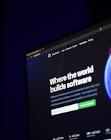 A computer screen displays a website with the text 'Where the world builds software' prominently featured. Below the text, there are fields for users to input their email address, along with additional descriptions about the platform and its capabilities. The website has a dark background with bright text, indicating a professional tech-based service.