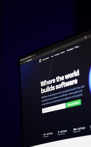 A computer screen displays a website with the text 'Where the world builds software' prominently featured. Below the text, there are fields for users to input their email address, along with additional descriptions about the platform and its capabilities. The website has a dark background with bright text, indicating a professional tech-based service.